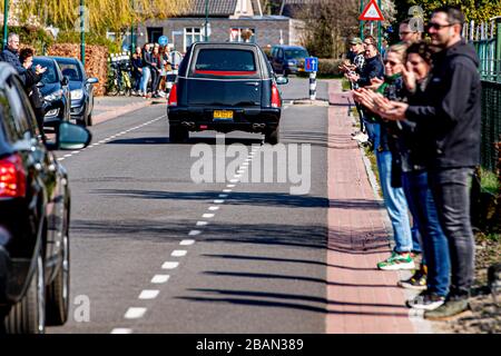 I residenti locali pagano il rispetto come il cuore che trasporta il cadavere della vittima del coronavirus guida attraverso il villaggio vicino a Uden durante una processione funeraria.solo un massimo di 30 persone possono visitare un funerale o cremazione, questo è riportato dal BGNU, l'associazione di settore del settore funerale. Sarà discusso con il prossimo di parenti che saranno invitati. Per evitare che il virus si diffonda, caffè e tè non sono più serviti. Foto Stock