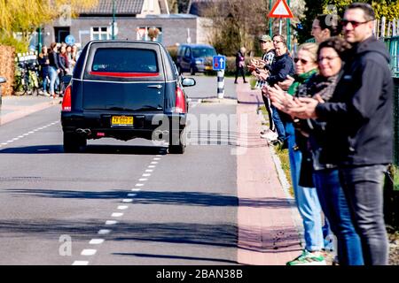 I residenti locali pagano il rispetto come il cuore che trasporta il cadavere della vittima del coronavirus guida attraverso il villaggio vicino a Uden durante una processione funeraria.solo un massimo di 30 persone possono visitare un funerale o cremazione, questo è riportato dal BGNU, l'associazione di settore del settore funerale. Sarà discusso con il prossimo di parenti che saranno invitati. Per evitare che il virus si diffonda, caffè e tè non sono più serviti. Foto Stock