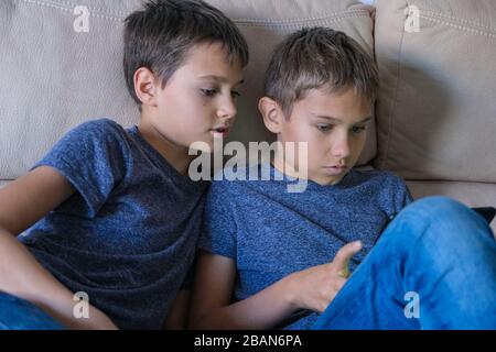 I bambini che utilizzano il computer tablet digitale a casa. Tecnologia, apprendimento online, formazione a distanza, giochi educativi per bambini Foto Stock