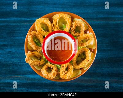 Frutti di mare - Fried Calamari. Calamari fritti conditi con foglie di insalata, prezzemolo, olive e limone. Isolato su sfondo bianco. Foto Stock