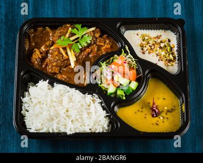 Cibo indiano tra cui curry, riso, samosa e pane naan. Foto Stock