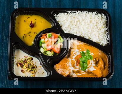 Cibo indiano tra cui curry, riso, samosa e pane naan. Foto Stock