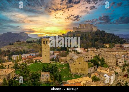 Veduta aerea della città di San Leo e della fortezza usata una volta come prigione su uno sperone roccioso vicino al mare Adriatico Rimini e San Marino con chiesa romana Foto Stock