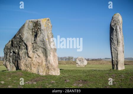 Pietre in piedi che formano il cerchio di pietra neolitico nel villaggio di Avebury, Wiltshire in un giorno di febbraio soleggiato. Foto Stock
