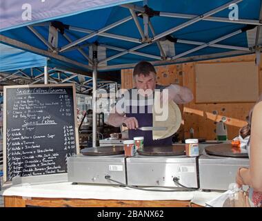 Uomo che piega una crepe, Crepe Stand, mercato antico, Kingston upon Thames. Inghilterra. Foto Stock