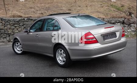 Mercedes-Benz Classe e isolata - alias W211, colore metallizzato oro, ornamenti cromati, finestre azzurre,anno 2004,angolo posteriore sinistro, tronco,Avantgarde Foto Stock