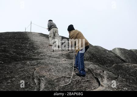 Petrópolis, Brasile, 13 marzo 2020. Uomini che arrampicano sulla roccia di Cabo a Castelos do Açú nel Parco Nazionale della Serra dos Órgãos, al punto più alto della città Foto Stock