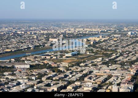 Veduta aerea di Urgench, Uzbekistan. Shavat Canal visibile insieme a ponti e basse case uzbeche. Khorezm Regione. Foto Stock