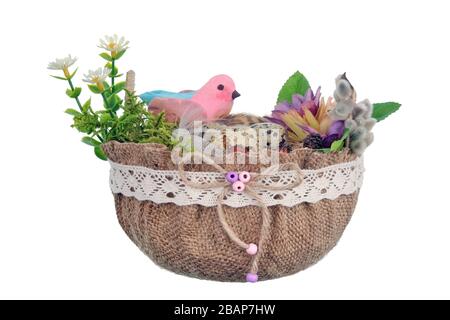 Nido di Pasqua fatto a mano da tela e fiori con divertente uccello di argilla rosa e uova di quaglia . Isolato su bianco studio macro shot Foto Stock