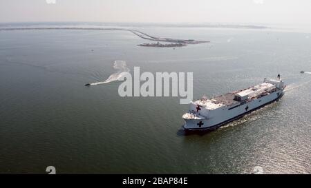 Norfolk, Stati Uniti. 28 Marzo 2020. La nave dell'ospedale militare Sealift Command USNS Comfort (T-AH 20) parte dalla stazione navale Norfolk, Virginia, 28 marzo 2020. Il comfort si sta sviluppando a sostegno degli sforzi di risposta del nationÕs COVID-19 e fungerà da ospedale di riferimento per pazienti non COVID-19 attualmente ammessi in ospedali a terra. In questo modo gli ospedali con sede a terra possono concentrare i propri sforzi sui casi COVID-19. Una delle missioni del Dipartimento di DefenseÕs è il sostegno alla difesa delle autorità civili. Credit: Storms Media Group/Alamy Live News Foto Stock