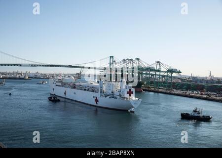 Los Angeles, Stati Uniti. 27 marzo 2020. La nave dell'ospedale militare Sealift Command USNS Mercy (T-AH 19) arriva a Los Angeles, California, 27 marzo 2020. Mercy è stata impiegata a sostegno degli sforzi di risposta del nationÕs COVID-19 e fungerà da ospedale di riferimento per i pazienti non COVID-19 attualmente ammessi negli ospedali a terra. Ciò consente agli ospedali della base costiera di concentrare i propri sforzi sui casi COVID-19. Una delle missioni del Dipartimento di DefenseÕs è il sostegno alla difesa delle autorità civili. DOD sta sostenendo l'Agenzia federale di gestione delle emergenze, l'agenzia federale principale, così come lo stato, locale e pubblico Foto Stock