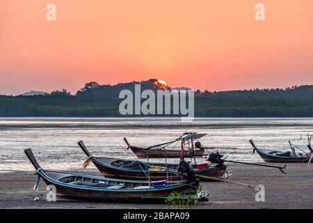 Barche a coda lunga con bassa marea al tramonto sull'isola Ko Yao noi nella baia di Phang-Nga vicino a Phuket nella Thailandia meridionale Foto Stock