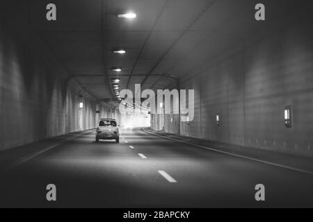 Fiat 500 classica che attraversa il tunnel, foto sfocata in bianco e nero Foto Stock