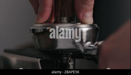 uomo che tamping fresco macinato caffè primo piano, foto ampia Foto Stock