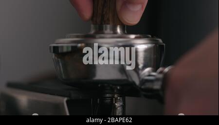 uomo che tamping fresco macinato caffè primo piano, foto ampia Foto Stock