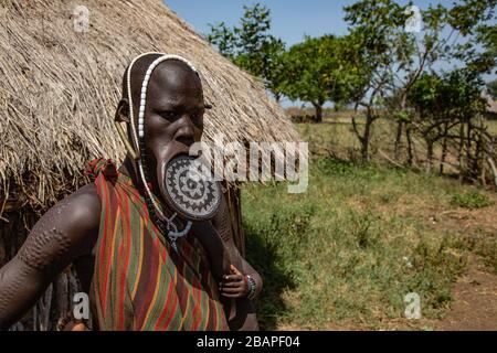 Donna della tribù Mursi con disco di argilla labbro come corpo Omo zona, Etiopia. Vicino al confine sudanese. Foto Stock