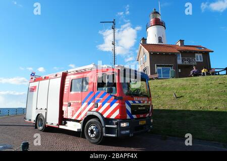 Urk Flevoland Paesi Bassi aprile 2017, nuovo camion olandese per il fuoco rosso, motore antincendio in piedi in font del faro con vigili del fuoco o vigili del fuoco all'interno, Foto Stock