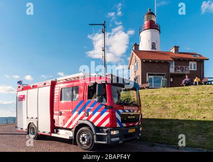 Urk Flevoland Paesi Bassi aprile 2017, nuovo camion olandese per il fuoco rosso, motore antincendio in piedi in font del faro con vigili del fuoco o vigili del fuoco all'interno, Foto Stock