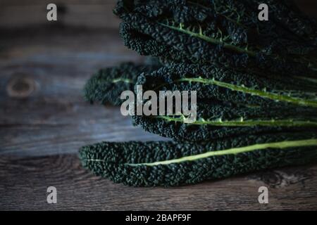 Mazzo di Kale nero su tavolo di legno Foto Stock