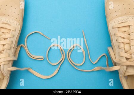 Word Cool scritto con lacci di nuove scarpe su sfondo blu. Foto Stock