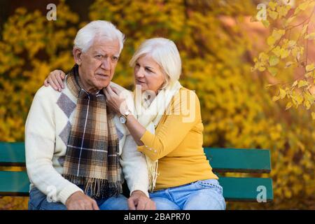 L'uomo anziano, sofferente, è consolato dalla donna anziana Foto Stock