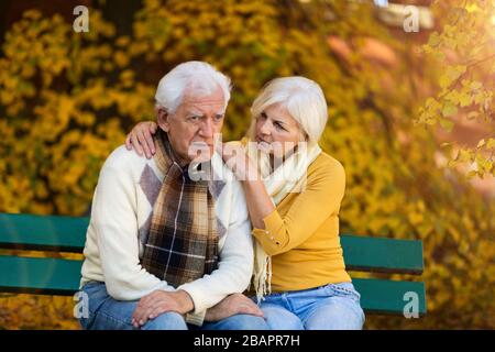 L'uomo anziano, sofferente, è consolato dalla donna anziana Foto Stock