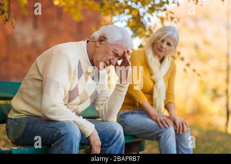 L'uomo anziano, sofferente, è consolato dalla donna anziana Foto Stock