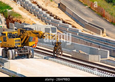 Escavatore ferroviario per la ricostruzione delle rotaie ferroviarie Foto Stock