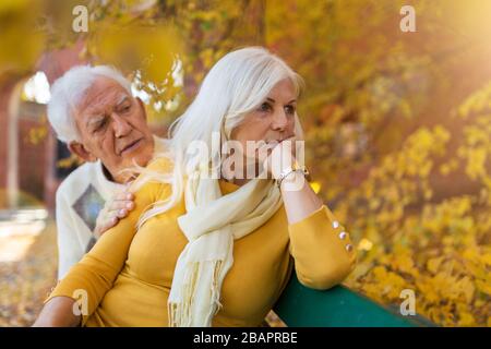 Donna anziana depressa consolata dall'uomo anziano Foto Stock