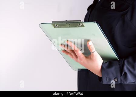 Mano di una donna che compila la lista di controllo su una clipboard, copia spazio Foto Stock