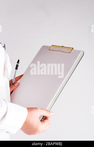 Mano di una donna che compila la lista di controllo su una clipboard, copia spazio Foto Stock