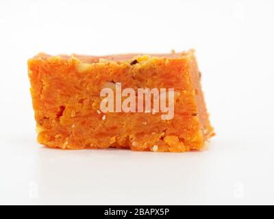 Primo piano di un pezzo di Gajur Ka Halwa, Londra, Regno Unito su uno sfondo bianco Foto Stock