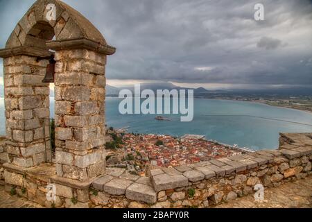 Città vecchia di Nafplion in Grecia, vista dall'alto con tetti in tegole, piccolo porto e castello di Bourtzi sull'acqua di mare mediterranea Foto Stock