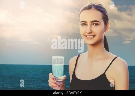 Ritratto di giovane donna acqua potabile, all'aperto, con copyspace Foto Stock