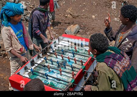 Luogo di mercato. Sbarcare. Simien Mountains. Nord dell'Etiopia. Sbarcare sul mercato. Parecchi bambini giocare a biliardino mentre i loro genitori sono la vendita o l'acquisto. Th Foto Stock