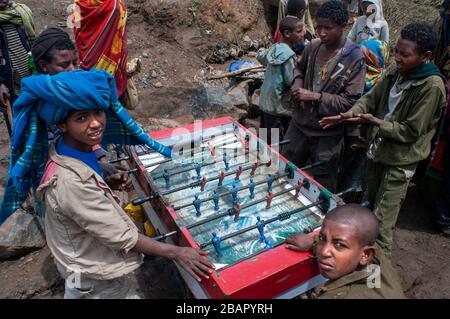 Luogo di mercato. Sbarcare. Simien Mountains. Nord dell'Etiopia. Sbarcare sul mercato. Parecchi bambini giocare a biliardino mentre i loro genitori sono la vendita o l'acquisto. Th Foto Stock