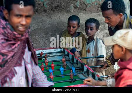 Luogo di mercato. Sbarcare. Simien Mountains. Nord dell'Etiopia. Sbarcare sul mercato. Parecchi bambini giocare a biliardino mentre i loro genitori sono la vendita o l'acquisto. Th Foto Stock