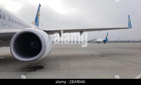 Ucraina, Borispol - 27 marzo 2020: Turbina a motore e ala di un grande aereo passeggeri in attesa di partenza all'aeroporto sullo sfondo del Foto Stock