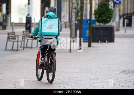 Glasgow, Regno Unito. 27 marzo 2020. Nella foto: Il ciclista di Deliveroo visto consegnare il Pandemic Coronavirus ha costretto il governo britannico a ordinare la chiusura di tutte le principali città del Regno Unito e far rimanere le persone a casa, che ha lasciato le autostrade e tutte le altre strade libere dal solito traffico naso a coda che altrimenti sarebbe lì. Credit: Colin Fisher/Alamy Live News. Foto Stock