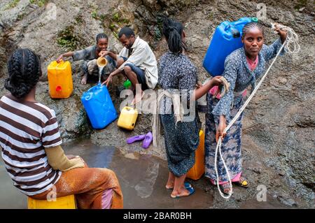 Strada tra da Wukro a Mekele, Etiopia. Sulla strada tra Wukro e Mekele diverse persone raccolgono acqua e la possibilità di fare il bagno in una s Foto Stock