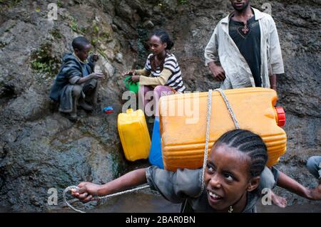 Strada tra da Wukro a Mekele, Etiopia. Sulla strada tra Wukro e Mekele diverse persone raccolgono acqua e la possibilità di fare il bagno in una s Foto Stock