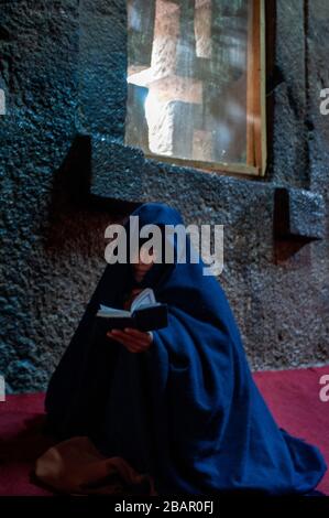 Lalibela, Amhara Region, Etiopia. Una donna che prega all interno della chiesa Bet Medhane Alem. Per ammirare le chiese di Lalibela non bisogna guardare upwa Foto Stock
