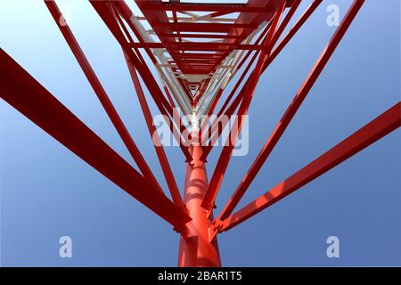 La fotografia offre una prospettiva verso l'alto della struttura interna di una torre di telecomunicazioni. L'immagine rivela la complessa struttura in acciaio che c Foto Stock