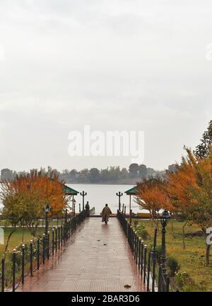 Uomo che cammina verso un lago Foto Stock