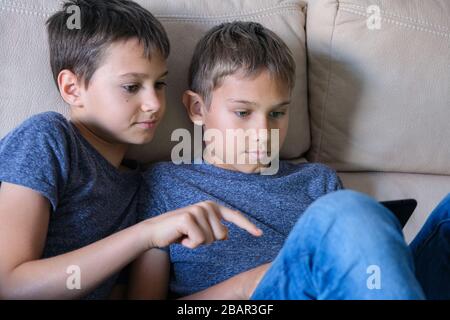 I bambini che utilizzano il computer tablet digitale a casa. Tecnologia, apprendimento online, formazione a distanza, giochi educativi per bambini Foto Stock