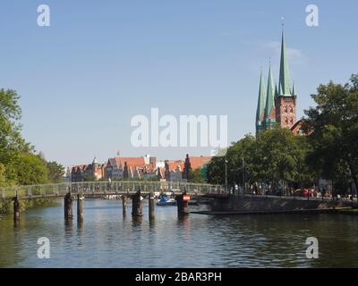 Lübeck Germania, giornata estiva soleggiato, skyline con il fiume Trave e la Chiesa di San Pietro Foto Stock