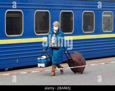 Kiev, Ucraina. 29 marzo 2020. Una donna Ucraina che è stata evacuata in treno dalla Russia, a causa della diffusione del coronavirus COVID-19 passeggiate all'arrivo alla stazione ferroviaria centrale di Kiev, Ucraina, il 29 marzo 2020. I cittadini ucraini che, a causa di misure restrittive in relazione alla quarantena a causa del coronavirus diffuso COVID-19 non sono in grado di attraversare il confine, sono stati evacuati dal treno speciale dalla Russia. Credit: Serg Glovny/ZUMA Wire/Alamy Live News Foto Stock