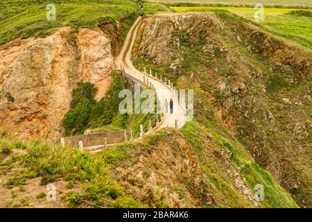 La Coupée, uno stretto istmo di terra tra il Grande Sark e Little Sark (primo piano) nelle Isole del canale del Regno Unito. Strada costruita nel 1945 dai prigionieri tedeschi. Foto Stock