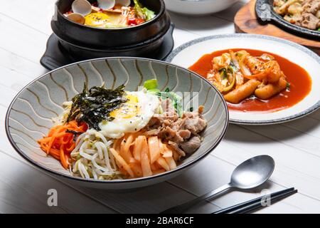 Bibimbap viene servito come una ciotola di riso bianco caldo sormontata da verdure o kimchi e pasta di peperoncino e uovo, carne a fette Foto Stock