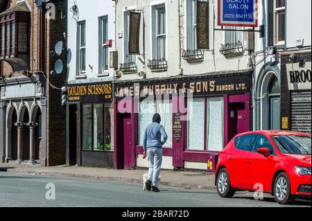 Bandon, West Cork, Irlanda. 29 marzo 2020. Un adolescente cammina il suo cane lungo una strada principale di Bandon quasi deserta questa mattina il giorno 2 dell'ordine obbligatorio 'giorno a casa' del governo. L'ordine è in vigore fino al 12 aprile. Credit: Andy Gibson/Alamy Live News Foto Stock